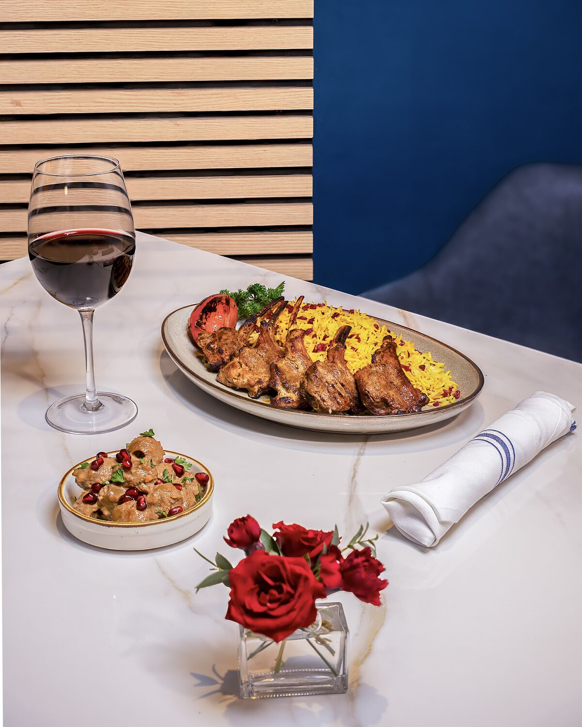 Grilled lamb chops with saffron rice, fesenjan and a glass of red wine in Westwood Village